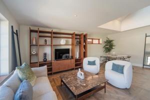 uma sala de estar com um sofá e uma mesa em Monaco Poolside Apartment em Nelson