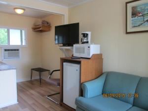 a living room with a couch and a tv at Motel Jann in Quebec City