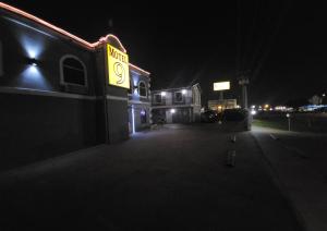拉雷多的住宿－Motel 9，一座建筑,在黑暗中标有黄色的酒店标志