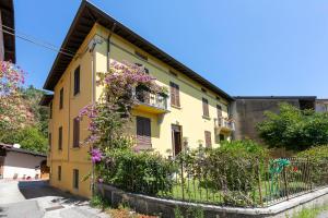 a yellow house with flowers on the side of it at Vicolo 42-private Terrace-200m Lake - Happy Rentals in Salò