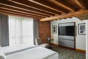 a bedroom with a bed and a flat screen tv at Manchester Marriott Victoria & Albert Hotel in Manchester