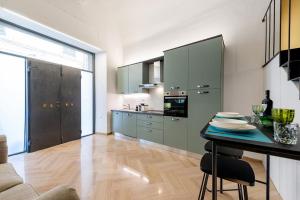 a kitchen with green cabinets and a table with plates on it at Loft Corso Cavour in Perugia