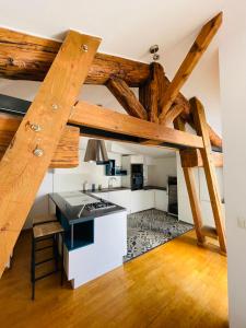 eine Küche im Dachgeschoss mit Holzbalken und weißen Arbeitsflächen in der Unterkunft Le Confidentiel - terrasse et garage privé in Nîmes
