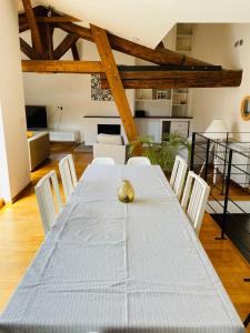 ein Esszimmer mit einem weißen Tisch und weißen Stühlen in der Unterkunft Le Confidentiel - terrasse et garage privé in Nîmes