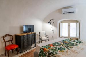 a bedroom with a bed and a tv and a dresser at Loft Corso Cavour in Perugia