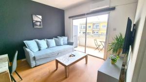 ein Wohnzimmer mit einem blauen Sofa und einem Tisch in der Unterkunft 2 Apts - 12 guests! Comfy and Unique Apt with 150Mbit internet speed in Larnaka