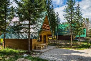 uma cabana de madeira com um banco à frente em Ville Uskoci em Žabljak