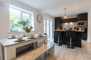 a kitchen with a dining table and a clock on the wall at No40Barmouth-Modern,Spacious&Hot Tub in Barmouth