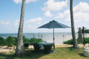 een tafel met een parasol op het strand bij Aloha Beachfront ホノルル - Hawaii Kai in Honolulu