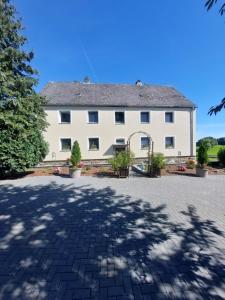 a large white building with trees in front of it at Altes Zollhaus in Hallschlag