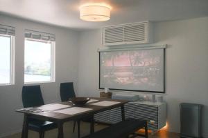 a dining room with a table and a large painting on the wall at Aloha Beachfront ホノルル - Hawaii Kai in Honolulu