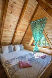 uma cama num chalé de madeira com uma janela em Ville Uskoci em Žabljak