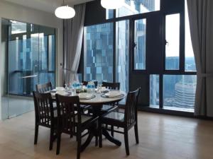 a dining room with a table and chairs and large windows at Star KLCC By B&B in Kuala Lumpur