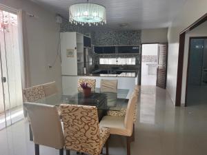 uma sala de jantar e cozinha com uma mesa de vidro e cadeiras em Casa alto padrão mobiliada em Macapá