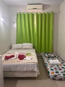 um quarto com 2 camas e uma cortina verde em Casa alto padrão mobiliada em Macapá