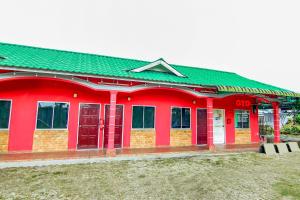 czerwony budynek z czerwonymi drzwiami i zielonym dachem w obiekcie Tangkak Mawadahh Inn Stay w mieście Tangkak