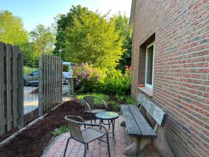 a patio with a table and chairs next to a brick building at Deich Quartier 9.2 in Dorum Neufeld