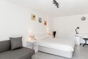 a white bedroom with a bed and a couch at Arrábida Guest Studio in Aldeia Rica