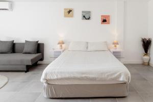 1 dormitorio con 1 cama grande y 1 sofá en Arrábida Guest Studio, en Aldeia Rica