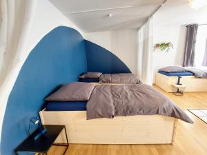 1 dormitorio con 1 cama con pared azul en Viel Platz für Gruppen inkl. Waschmaschine, Hochstuhl und Playstation mitten in der Altstadt en Amberg