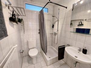 a white bathroom with a toilet and a sink at Viel Platz für Gruppen inkl. Waschmaschine, Hochstuhl und Playstation mitten in der Altstadt in Amberg