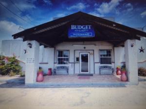 un edificio con una señal azul en la parte delantera en Budget Inn & Suites Lowest Price,Best Value!!!, en Freer