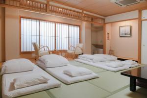 a room with four beds in it with a table at Yuno Yado Shoei in Kyoto