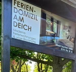 a sign in front of a house with a porch at Deich Quartier 9.3 in Dorum Neufeld