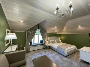 um quarto com paredes verdes, uma cama e um lustre em WineGarden em Mukacheve