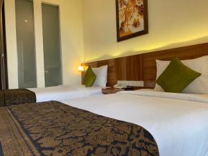 Habitación de hotel con 2 camas y teléfono en Argya Santi Resort, en Jimbaran