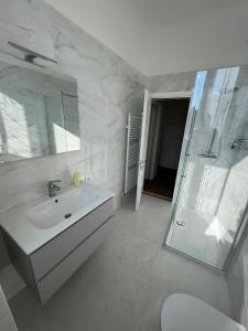 a white bathroom with a sink and a shower at Appartamento con terrazzo in Orvieto