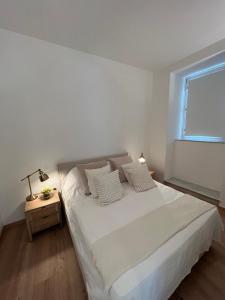 a white bedroom with a bed and a window at Appartamento con terrazzo in Orvieto