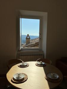 a table with two plates and a window at Appartamento con terrazzo in Orvieto