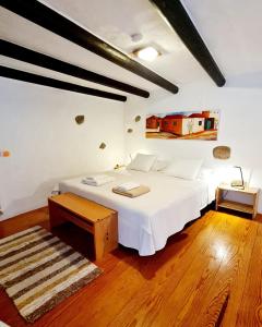 a bedroom with a white bed and a wooden floor at Luana House in Teguise