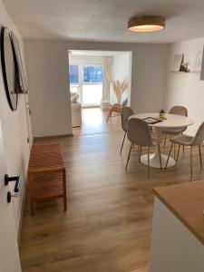 Una cocina y una sala de estar con mesa y sillas. en L'Essentiel, en Dinant
