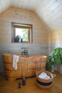 Cette chambre dispose d'une baignoire en bois et d'une fenêtre. dans l'établissement Bratkowa Chata, à Binczarowa