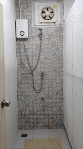 a shower with a hose attached to a tiled wall at Chiang Mai Happy House Hostel in Chiang Mai