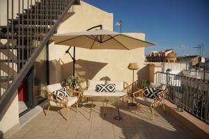 a patio with a table and chairs and an umbrella at Cathedral Sevilla Views in Seville