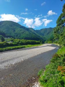 a river with mountains in the background at 民宿 和合 Minshuku WAGO in Tanabe
