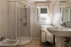 バルドリーノにあるAppartamenti Montefeliceの白いバスルーム(シャワー、シンク付)