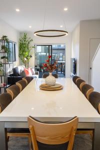 a dining room with a large white table and chairs at Walk to Riverside Market 4 bed 4 bath with car park in Christchurch