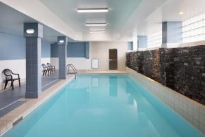 - une piscine d'eau bleue dans un bâtiment dans l'établissement Four Points by Sheraton Edmonton South, à Edmonton