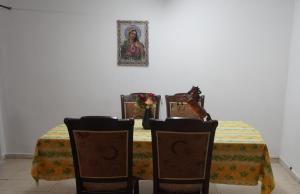 a dining room table with a yellow table cloth and chairs at Lovely Lama Family House in Bethlehem