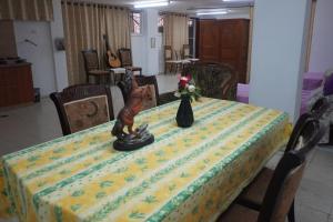 a table with a yellow table cloth with a figurine on it at Lovely Lama Family House in Bethlehem