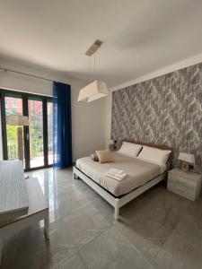 a bedroom with a large bed and a wall at La Peonia in Castellammare di Stabia