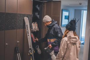 a man and a woman are looking at skis at Landhaus Saalbach - Ski in & out in Saalbach Hinterglemm
