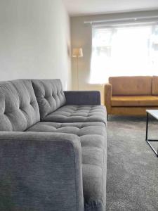 Sala de estar con sofá gris y mesa en Spacious Contemporary Home en Leeds