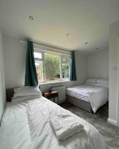 1 dormitorio con 2 camas y ventana en Spacious Contemporary Home en Leeds