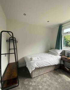 a bedroom with a bed with a ladder and a desk at Spacious Contemporary Home in Leeds