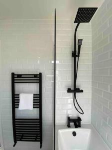 Baño blanco con espejo y lavabo en Spacious Contemporary Home en Leeds
